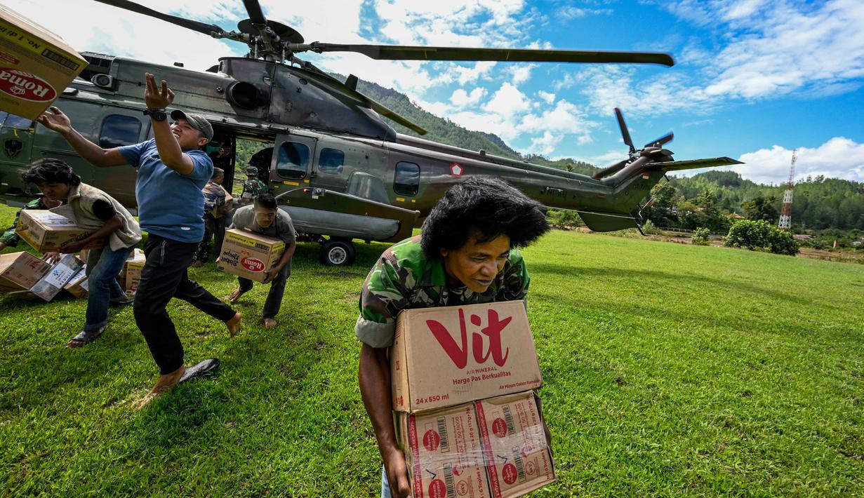 Keempat kabupaten tersebut adalah Bener Meriah, Aceh Tengah, Gayo Lues, dan Aceh Tamiang. Tampak dalam foto, warga membawa bantuan yang didistribusikan oleh personel TNI AU di wilayah terdampak banjir di Kabupaten Bener Meriah, Provinsi Aceh, pada Kamis 4 Desember 2025. (CHAIDEER MAHYUDDIN/AFP)
