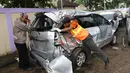 Petugas makukan evakuasi mobil yang rusak akibat terjangan Tsunami Selat Sunda di Terminal Carita, Banten, Selasa (25/12). Di terminal ini pemilik mobil dapat mengambilnya yang disertai dengan STNK. (Liputan6.com/Angga Yuniar)
