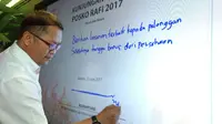 Menkominfo Rudiantara menuliskan pesan dan menandatangani Kunjungan Ramadan dan Idul Fitri (RAFI) 2017 secara digital di Telkomsel Smart Office di Jakarta. (Liputan6.com/Corry Anestia)