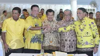 Wapres Jusuf Kalla (tengah) bersama Ketum Partai Golkar versi munas Bali Aburizal Bakrie, Ketum Partai Golkar versi munas Ancol Agung Laksono berjabat tangan setelah penandatanganan kesepakatan islah di Jakarta, Sabtu (30/5). (Liputan6.com/Johan Tallo)