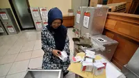 Anggota Panitia Pemungutan Suara (PPS) menghitung jumlah kertas suara surat sebelum disegel dalam kotak suara, Jakarta, Senin (7/7/14). (Liputan6.com/Faizal Fanani) 