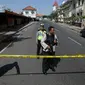 Aparat kepolisian menutup jalan menuju Polrestabes Surabaya setelah serangan bom bunuh diri di Jawa Timur, Senin (14/5). Diduga, pelaku seorang pria dan wanita yang berboncengan dengan sepeda motor dan membawa seorang anak kecil (AP/Achmad Ibrahim)