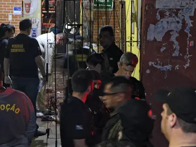 Sejumlah petugas saat mengevakuasi korban penembakan massal di sebuah bar di kota Belm, negara bagian utara Par, Brazil (19/5/2019). Sebanyak 11 orang dilaporkan tewas dalam serangan yang dilakukan 7 pria bersenjata tersebut. (Claudio Pinheiro/Agencia Panamazonica/AFP)