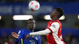 Pemain Arsenal Eddie Nketiah (kanan) berebut bola dengan pemain Chelsea N'Golo Kante pada pertandingan sepak bola Liga Inggris di Stamford Bridge, London, Inggris, 20 April 2022. Arsenal menang 4-2. (AP Photo/Frank Augstein)