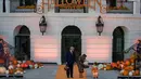 Presiden AS, Donald Trump dan ibu negara Melania Trump membagikan permen kepada anak-anak selama acara trick-or-treat Halloween di South Lawn, Gedung Putih, Senin (28/10/2019). Dalam acara ini anak-anak mengenakan kostum Halloween, sedangkan Donald dan Melania tetap tampil formal. (AP/Alex Brandon)
