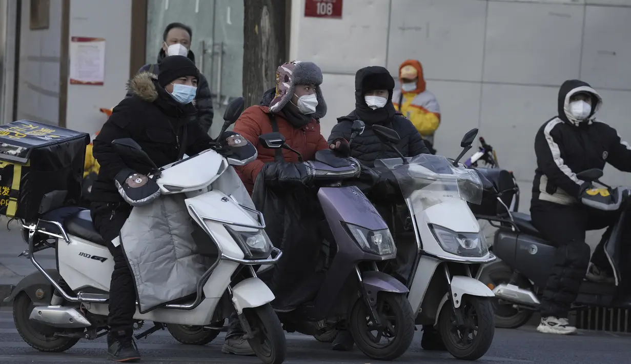 Pengantar barang melintasi persimpangan di Beijing, Kamis, 29 Desember 2022. China berada di jalan terjal untuk kembali ke kehidupan normal ketika warganya kembali ke sekolah, pusat perbelanjaan, dan restoran setelah berakhirnya kebijakan pembatasan paling parah di dunia diakhiri secara tiba-tiba, bahkan ketika rumah sakit dibanjiri pasien Covid-19 yang demam dan meriang parah. (AP Photo/Ng Han Guan)