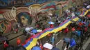 Demonstran membentangkan bendera Kolombia saat menggelar aksi mogok nasional di Bogota, Kolombia, (17/3). Aksi tersebut merupakan protes terhadap sejumlah kebijakan pemerintah. (REUTERS/John Vizcaino)