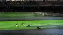 Orang-orang bermain kayak di sepanjang Sungai Chicago yang berwarna hijau jelang Hari Santo Patrick di Chicago, Amerika Serikat, Sabtu (13/3/2021). Kegiatan mewarnai Sungai Chicago dalam rangka memperingati Hari Santo Patrick sudah berlangsung selama 40 tahun. (Pat Nabong/Chicago Sun-Times via AP)