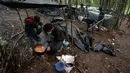 Migran memasak di kamp darurat di hutan di luar Velika Kladusa, Bosnia pada 26 September 2020. Bosnia menjadi salah satu tempat singgah para imigran dan pengungsi dalam perjalanannya ke Eropa Barat. (AP Photo/Kemal Softic)