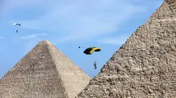 Para penerjun payung melayang di atas Piramida Agung dalam festival olahraga udara di Giza, Mesir, 8 November 2020. Parasut menghiasi langit Piramida Agung ketika puluhan penerjun payung kelas dunia berpartisipasi dalam festival olahraga udara ketiga pada 8-9 November. (Xinhua/Ahmed Gomaa)