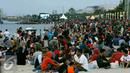 Ribuan pengunjung duduk dipinggir pantai menunggu pergantian tahun baru di Ancol, Jakarta, Sabtu (31/12). Tak hanya duduk-duduk, banyak pula yang bermain pasir dan berenang. (Liputan6.com/Angga Yuniar)