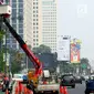 Petugas Suku Dinas PE Jakarta Pusat bersama Satgas PJU, mencabut dan menggeser tiang listrik dan lampu penerangan jalan yang menghalangi jalur sepeda di trotoar Jalan Asia Afrika dan Jalan Gelora, Senayan, Jakarta, Rabu (1/8). (Liputan6.com/Johan Tallo)