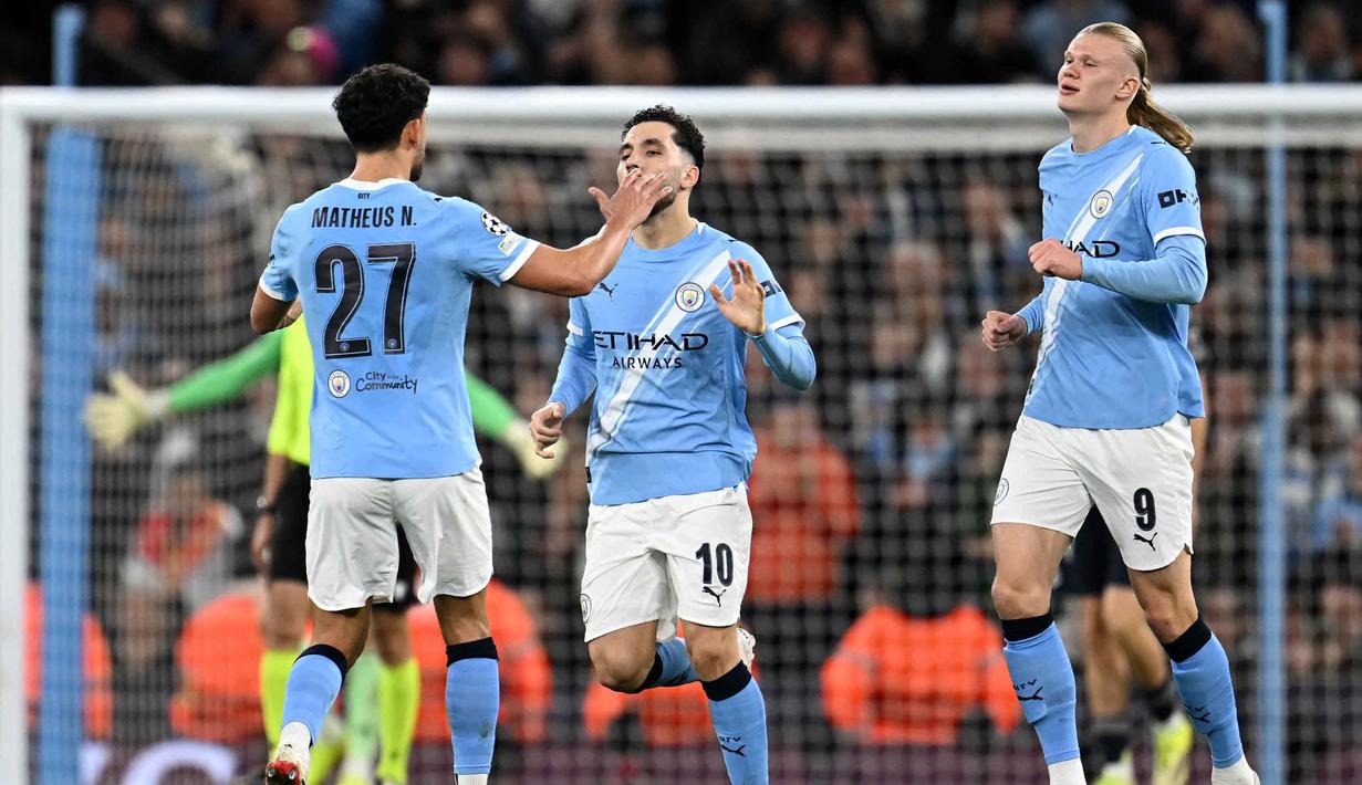 The Citizens baru bisa menyamakan kedudukan di menit ke-41 lewat aksi Erling Haaland. Skor pertandingan berubah imbang 1-1 dan bertahan hingga turun minum. Tampak dalam foto, striker Norwegia Manchester City, Erling Haaland (kanan) merayakan gol penyama kedudukan bersama gelandang Portugal Manchester City, Matheus Nunes (kiri) dan gelandang Prancis Manchester City Rayan Cherki selama pertandingan leg kedua 16 besar Liga Champions 2025/2026 melawan Real Madrid di Etihad Stadium, barat laut Inggris, pada Selasa 17 Maret 2026 waktu setempat atau Rabu (18/3) dini hari WIB. (Paul ELLIS/AFP)