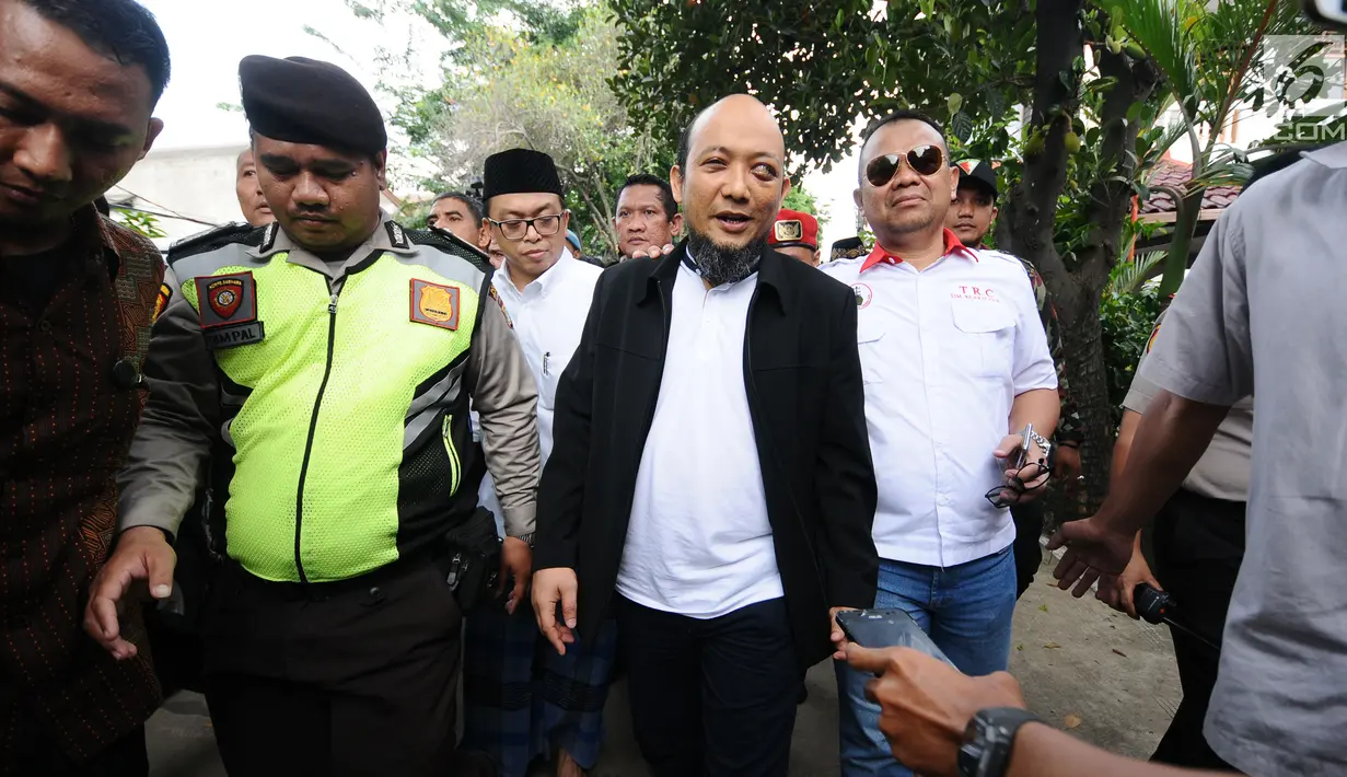 Penyidik KPK, Novel Baswedan (jas hitam) berjalan menuju kediaman di kawasan Kelapa Gading, Jakarta, Kamis (22/2). Novel kembali dalam proses pemulihan sambil menunggu jadwal operasi tahap kedua. (Liputan6.com/Helmi Fithriansyah)