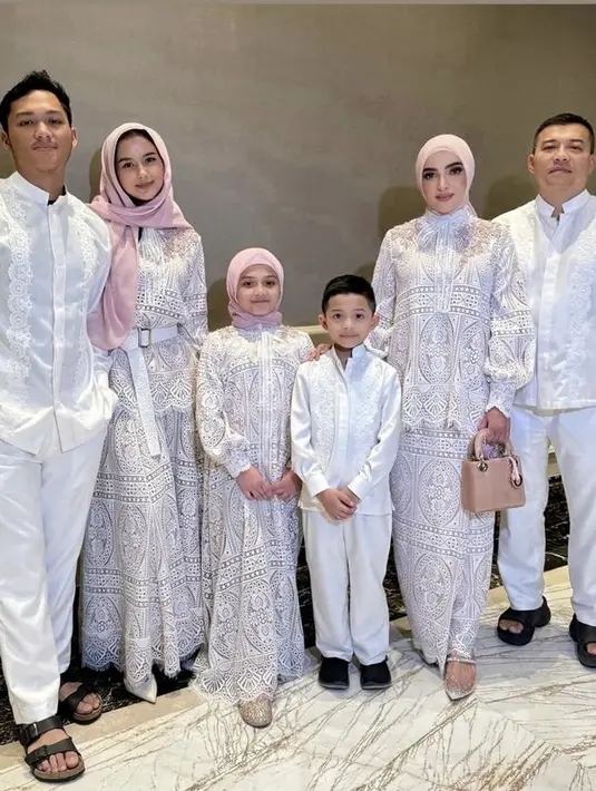 Sarah mengenakan kerudung pink tersebut yang hanya disemangatkan di kepalanya. Dipadukan gamis putih berbordir yang serasi dengan Ashanty dan Arsy. [@ashanty_ash]