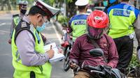 Polisi Lalu lintas menilang pengendara sepeda motor saat Operasi Patuh Jaya 2020 di Jalan Letjen Suprapto, Jakarta Pusat, Kamis (23/7/2020). Ditlantas Polda Metro Jaya menggelar Operasi Patuh Jaya 2020 hingga 5 Agustus untuk menertibkan masyarakat dalam berlalu lintas. (Liputan6.com/Faizal Fanani)