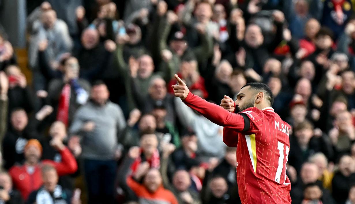 Pemain Liverpool, Mohamed Salah melakukan selebrasi setelah mencetak gol pertama timnya melalui tendangan penalti pada laga lanjutan Liga Inggris 2024/2025 melawan Chelsea di Anfield, Liverpool, Inggris, Minggu (20/11/2024). (AFP/Paul Ellis)