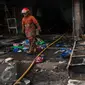 Petugas Damkar melintas di dekat bangunan yang terbakar di Pasar Senen, Jakarta, Kamis (19/1). Penyebab kebakaran masih dalam tahap penyelidikan. (Liputan6.com/Gempur M Surya)