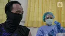 Tenaga kesehatan bersiap menyuntikkan vaksin COVID-19 pada tenaga pendidik di SMP 216, Jakarta Pusat, Selasa (6/4/2021). Pemerintah akan mengatur kembali pemberian vaksin Covid-19 kepada masyarakat karena terbatasnya pasokan vaksin saat ini. (Liputan6.com/Faizal Fanani)
