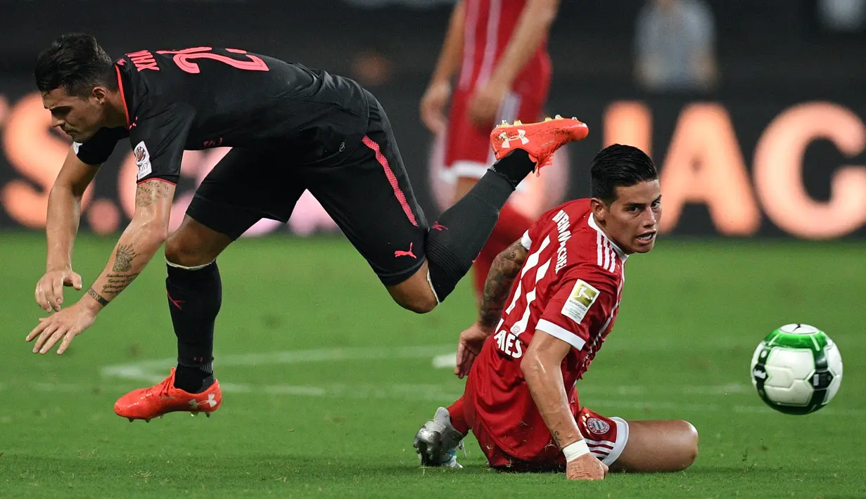 Gelandang Bayern Munchen, James Rodriguez, berebut bola dengan gelandang Arsenal, Granit Xhaka pada laga ICC 2017, di Stadion Shanghai, Rabu (19/7/2017). Arsenal menang adu penalti dengan skor 3-2 atas Bayern Munchen. (AFP/Johannes Eisele)