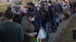 Orang-orang mengantri untuk menunggu jatah makanan dari organisasi World Central Kitchen di pusat kota Mykolaiv, Ukraina, Senin (24/10/2022). Akibat dari terputusnya aliran air ke kota tersebut menghancurkan sumber daya vital bagi kehidupan sipil secara luas. (AP Photo/Emilio Morenatti)