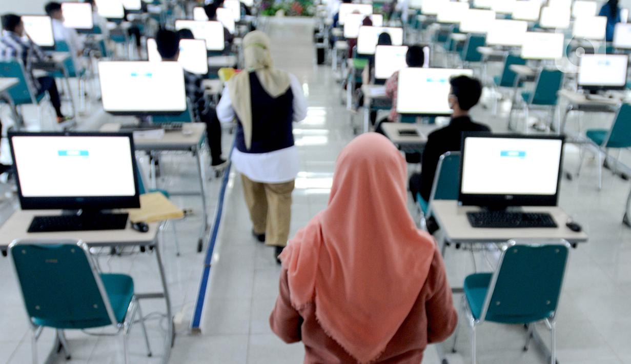 Petugas mengawasi pelaksanaan Ujian Tulis Berbasis Komputer (UTBK) Seleksi Bersama Masuk Perguruan Tinggi Negeri (SBMPTN) 2022 gelombang pertama di Universitas Pembangunan Nasional (UPN), Jakarta, Selasa (17/5/2022). UTBK SBMPTN 2022 digelar mulai hari ini hingga 23 Mei 2022. (merdeka.com/Arie Basuki)
