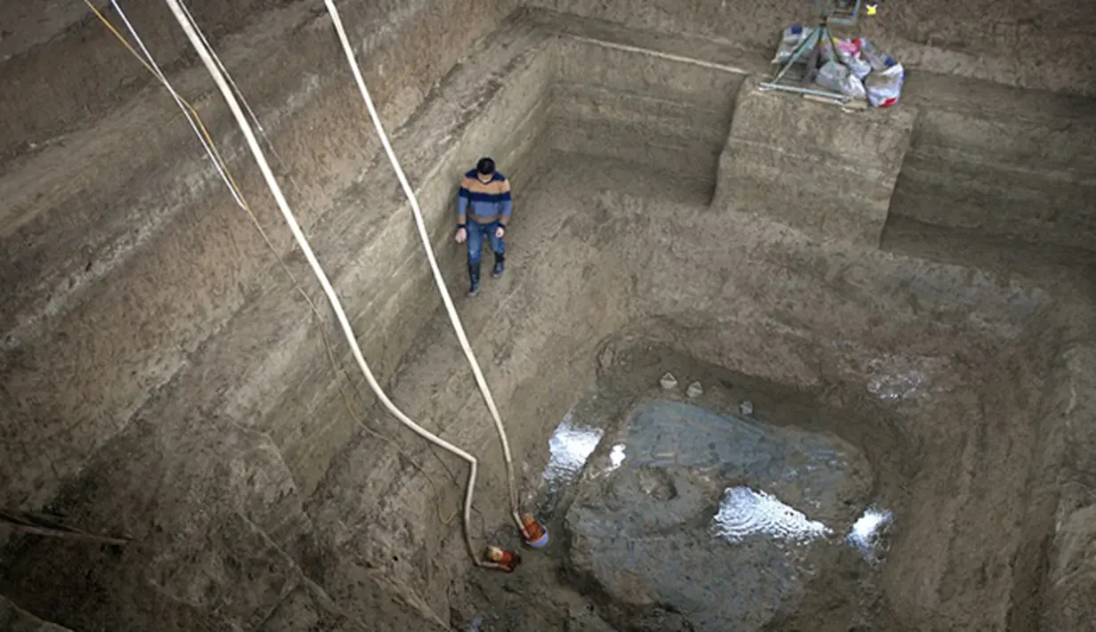 Peneliti saat berada didalam lubang yang masih terdapat air di makam penguburan kuda di Luoyang, Cina. Lubang yang memiliki panjang 25 kaki, Lebar 20 kaki dan kedalaman sembilan kaki terdapat 13 kuda dan enam kereta. (Dailymail) 
