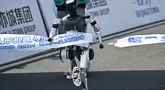 Sebuah robot melintasi garis finis dalam lomba lari setengah maraton robot humanoid di Beijing pada 19 April 2025. (Pedro PARDO/AFP)