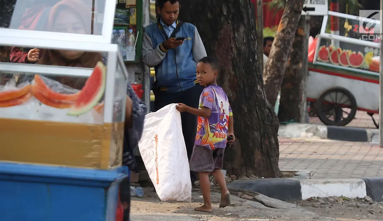 Seorang anak memungut sampah plastik di Jakarta, Rabu (12/9). Untuk mewujudkan target bebas pekerja anak pada 2022, Indonesia telah mengembangkan berbagai kebijakan. (Liputan6.com/Immanuel Antonius)