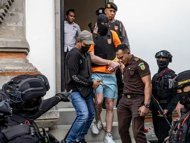 Salah satu tersangka kasus pembunuhan berencana terhadap warga negara Australia yaitu Zivan Radmanovic dan korban luka Sanar Ghanim, Darcy Francesco Jenson (tengah) dibawa kembali ke rumah tahanan setelah menjalani pemeriksaan oleh pihak kejaksaan di Badung, Bali, pada 15 Oktober 2025. (Dicky Bisinglasi/AFP)