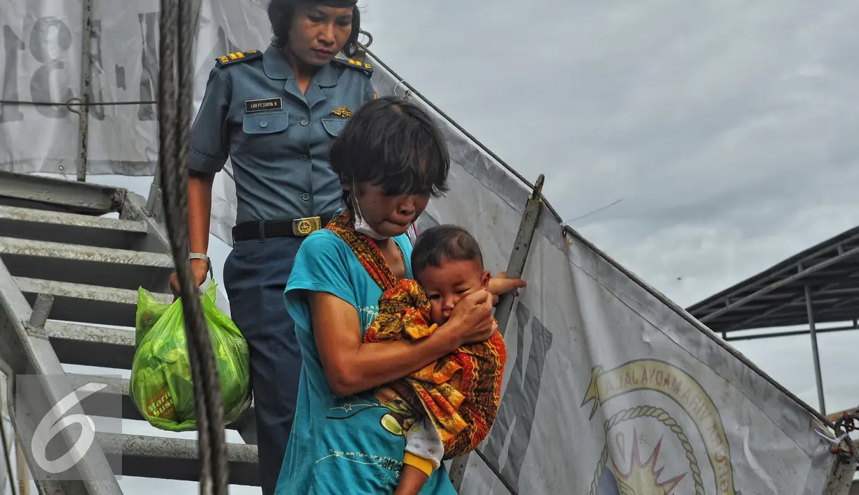 Petugas mendampingi mantan anggota Gafatar saat tiba di Pelabuhan Tanjung Emas, Semarang , Senin (25/1). Mantan anggota Gafatar Terbanyak berasal dari Daerah Istimewa Yogyakarta, dengan 110 KK terdiri 300 jiwa. (Liputan6.com/Gholib)