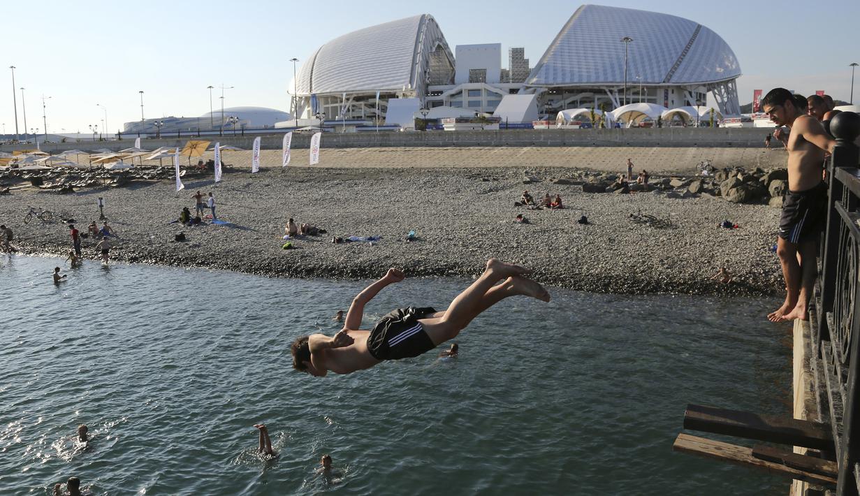 Sejumlah suporter mengisi waktu dengan melompat ke sungai saat berada di sekitar Stadion Fisht, Sochi, Senin (11/6/2018). Jelang Piala Dunia, para suporter mulai berdatangan ke Rusia. (AP/Andre Penner)