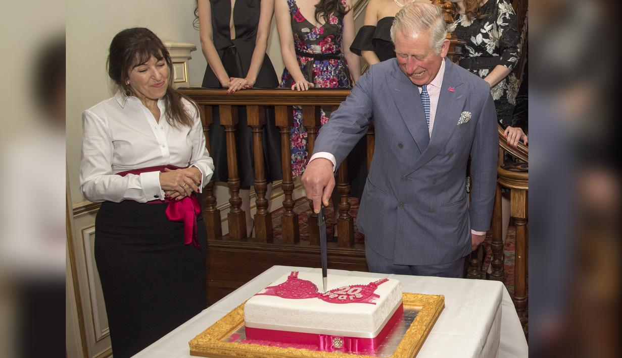 Pangeran Charles bersama pendiri Walk the Walk Nina Barough memotong kue bergambar bra saat menghadiri perayaan ulang tahun ke-20 Walk the Walk di Clarence House, London (23/11). (AFP PHOTO/POOL/Arthur Edwards)