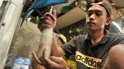 Pekerja membersihkan botol yang akan digunakan sebagai tempat bir pletok, Jakarta, Senin (6/2). Pemprov DKI luncurkan 8 ikon Budaya Betawi sebagai tindak lanjut Perda No 4 Tahun 2015 tentang Pelestarian Budaya Betawi. (Liputan6.com/Yoppy Renato)