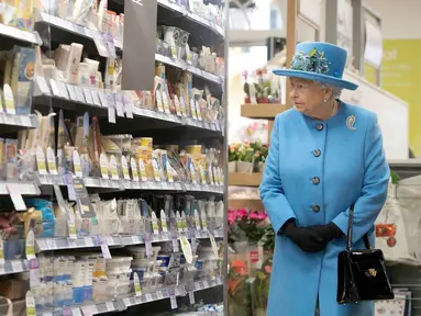 Ratu Inggris Elizabeth II melihat makanan di rak-rak pasar swalayan Waitrose selama kunjungannya ke Kota Poundbury, Inggris (27/10). Ratu Inggris yang berumur 90 tahun ini datang ke Poundbury juga untuk meresmikan patung ibundanya. (Reuters/Justin Tallis)