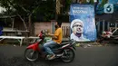 Pengendara sepeda motor melintas di depan poster Rizieq Shihab di Jalan Petamburan 3, Jakarta, Rabu (30/12/2020). Pemerintah memutuskan untuk menghentikan kegiatan dan membubarkan organisasi massa Front Pembela Islam (FPI). (merdeka.com/Imam Buhori)