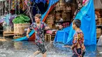 Anak-anak bermain di tengah banjir usai hujan deras yang tiba-tiba mengguyur di sebuah pasar dekorasi Natal di Manila, Filipina (9/12/2020). (Xinhua/Rouelle Umali)