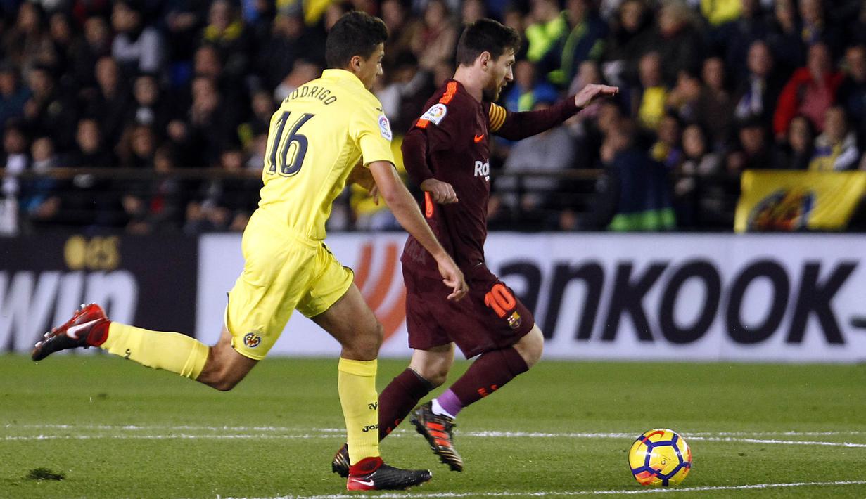 Striker Barcelona, Lionel Messi, berusaha melewati gelandang Villarreal, Rodrigo, pada laga La Liga, di Stadion De La Cerramica, Minggu (10/12/2017). Barcelona menang 2-0 atas Villarreal. (AP/Alberto Saiz)