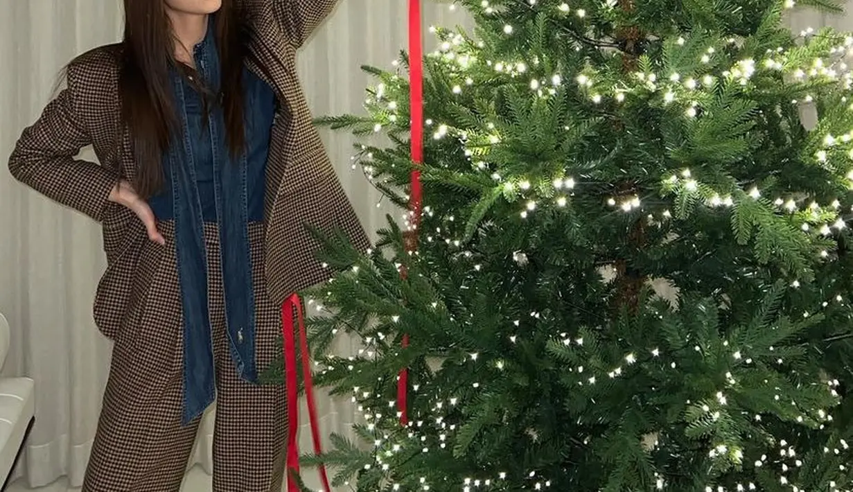 Krystal mengenakan setelan coklat dari atasan blazer dan celana panjangnya dipadukan inner denim. [@vousmevoyez]