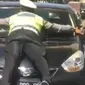 Tangkapan layar dari video polantas yang terbawa mobil dan viral di media sosial. (Liputan6.com/Huyogo Simbolon)