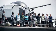 Sembilan Tersangka perompak dihadirkan oleh Anggota TNI AL di Surabaya, Jawa Timur, (10/5). Sembilan tersangka diduga melakukan pembajakan terhadap kapal tanker berbendera Singapura di perairan Tanjung Puting, Kalimantan. (AFP PHOTO/JUNI KRISWANTO)