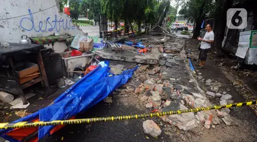 Warga berdoa di lokasi robohnya tembok SPBU di Jalan Tebet Barat Dalam Dua, Jakarta Selatan, Minggu (21/1/2024) siang. Robohnya tembok sepanjang sekitar 50 meter dan tinggi 3 meter saat angin kencang itu menyebabkan tiga warga tewas. (merdeka.com/Arie Basuki)