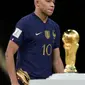 Pemain Prancis Kylian Mbappe berjalan melewati trofi juara dengan membawa trofi penghargaan Sepatu Emas usai melawan Argentina pada pertandingan sepak bola final Piala Dunia 2022 di Stadion Lusail, Lusail, Qatar, 18 Desember 2022. Kylian Mbappe berhak membawa pulang trofi penghargaan Sepatu Emas setelah menjadi pencetak gol terbanyak selama gelaran Piala Dunia 2022. (AP Photo/Martin Meissner)