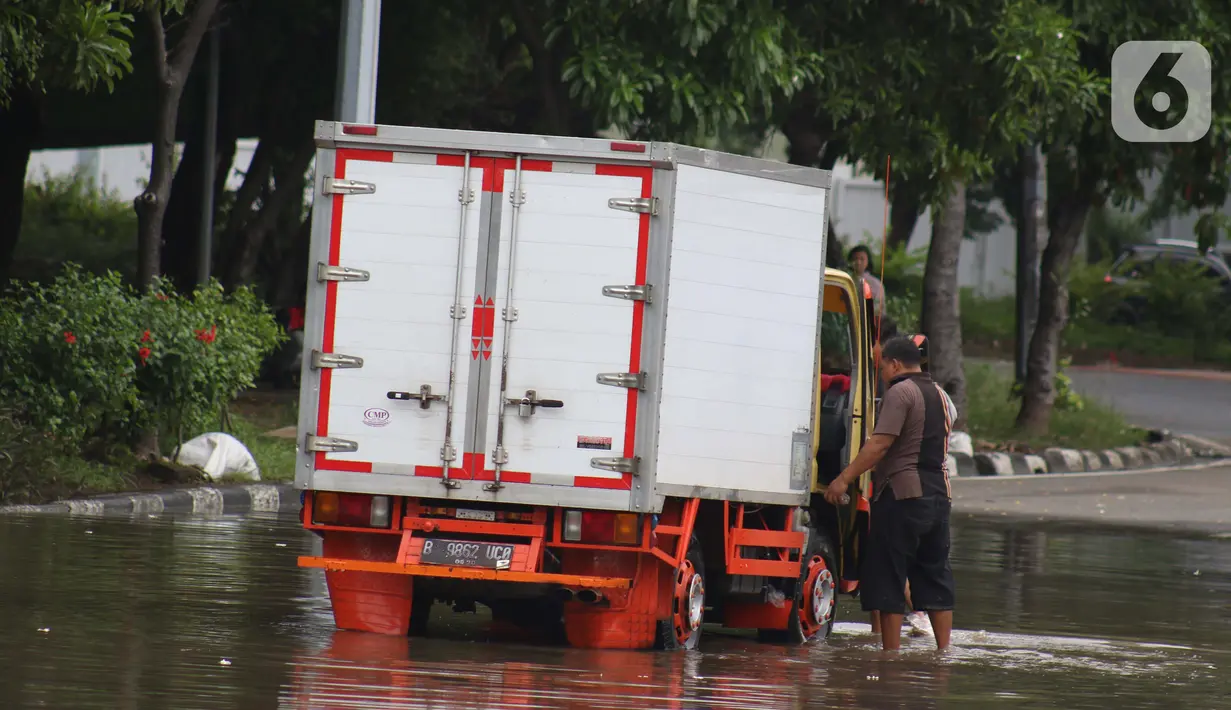 Pengendara memanfaatkan genangan air untuk mencuci kendaraan di Jalan HBR Motik Kemayoran, Jakarta, Selasa (25/2/2020). Hujan yang mengguyur Jakarta sejak Senin (24/2) malam membuat sejumlah kali meluap dan menyebabkan banjir. (Liputan6.com/Helmi Fithriansyah)