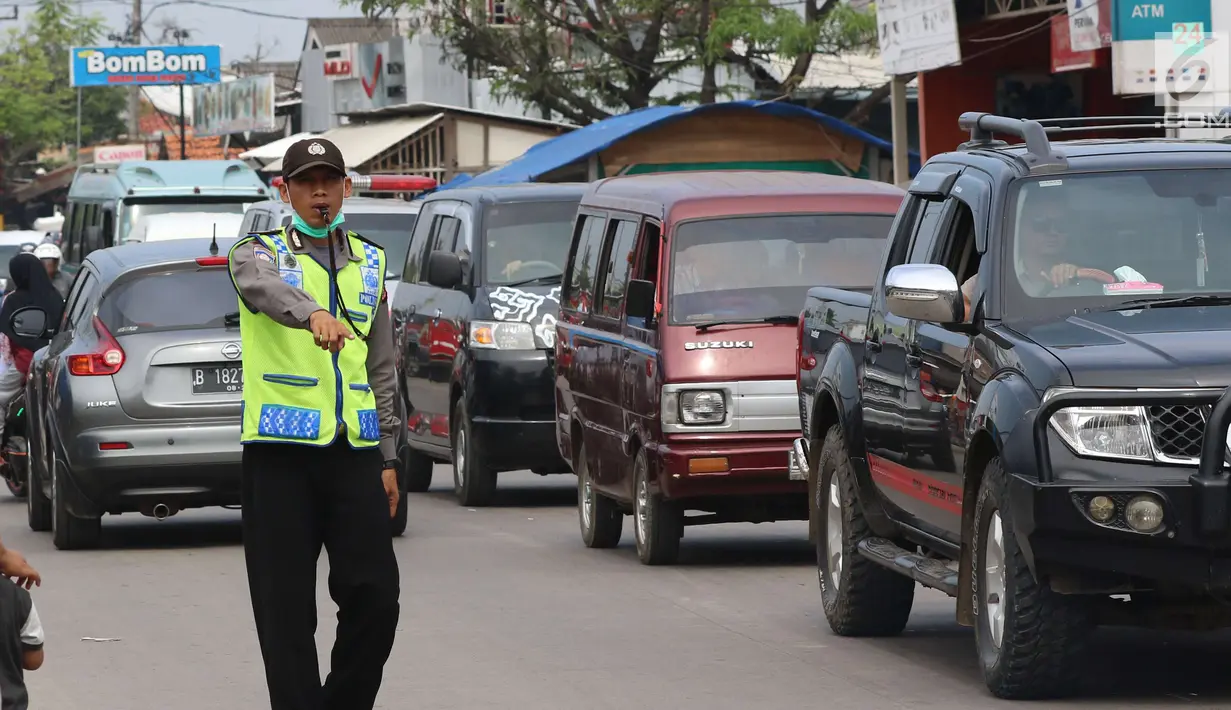 Petugas polisi mengatur lalu lintas di pasar Tumpah Bangkir Indramayu, Jawa Barat, Jumat (30/6). Sebaliknya kearah Indramayu Kota mengalami kemacetan arus lalu lintas sepanjang 3 Km. (Liputan6.com/Helm Afandi)