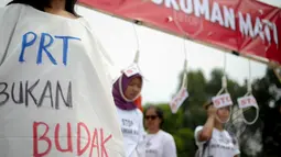 Massa Buruh Migrant memakai baju bertuliskan 'PRT Bukan Budak' saat menggelar aksi tolak hukuman mati yang bersamaan dengan peringatan Hari Buruh (May Day) di depan Istana Merdeka, Jumat (1/5/2015). (Liputan6.com/Faizal Fanani)