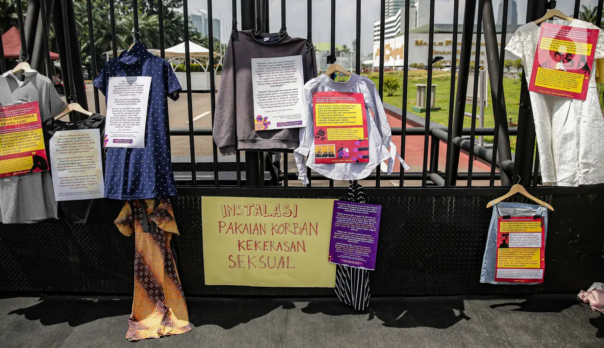 Instalasi pakaian korban kekerasan seksual dipajang di depan gerbang Gedung DPR, Jakarta, Rabu (22/12/2021). Massa yang tergabung dalam Jaringan Pembela Hak Perempuan Korban Kekerasan Seksual mendesak DPR mengesahkan RUU TPKS sebagai RUU Inisiatif DPR RI. (Liputan6.com/Faizal Fanani)