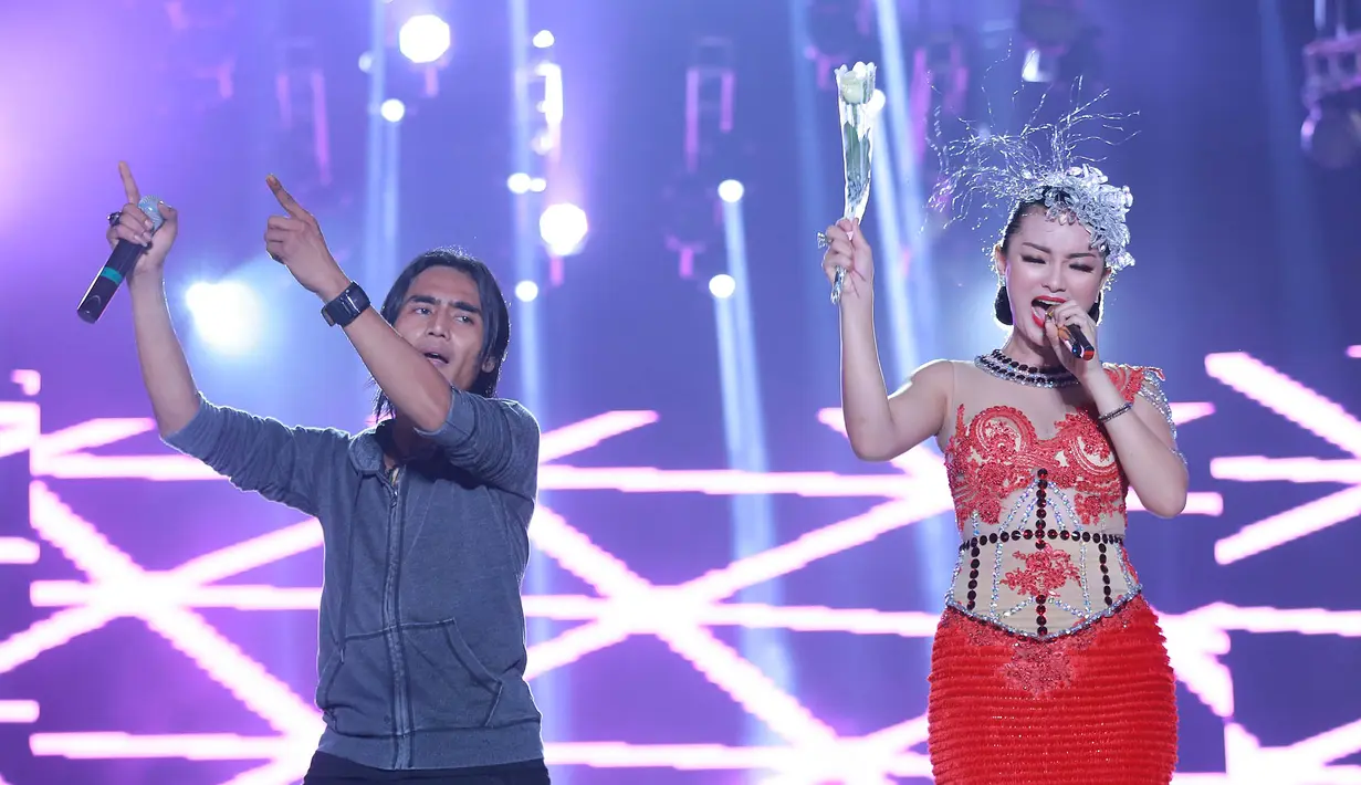 Zaskia Gotik dan Charly pentolan grup Setia Band menunjukkan semangat mereka dalam memberikan penampilan terbaik di akhir tahun 2015. Zaskia Gotik pun tampil cantik dalam balutan gaun berwarna merah terang. (Galih W. Satria/Bintang.com)