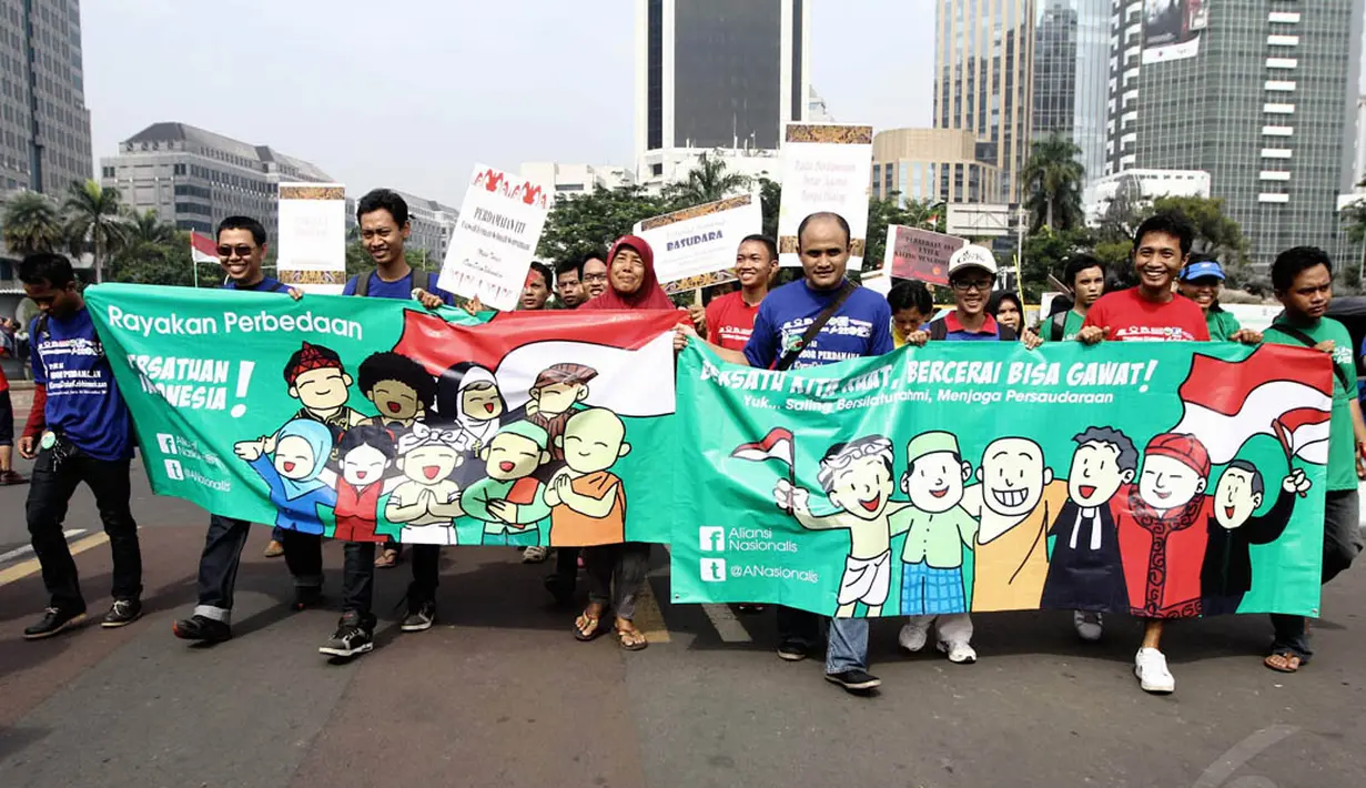 Peserta longmarch tampak membentangkan spanduk kerukunan umat beragama dalam acara perayaan Hari Toleransi Internasional, Jakarta, Minggu (16/11/2014). (Liputan6.com/Faizal Fanani)