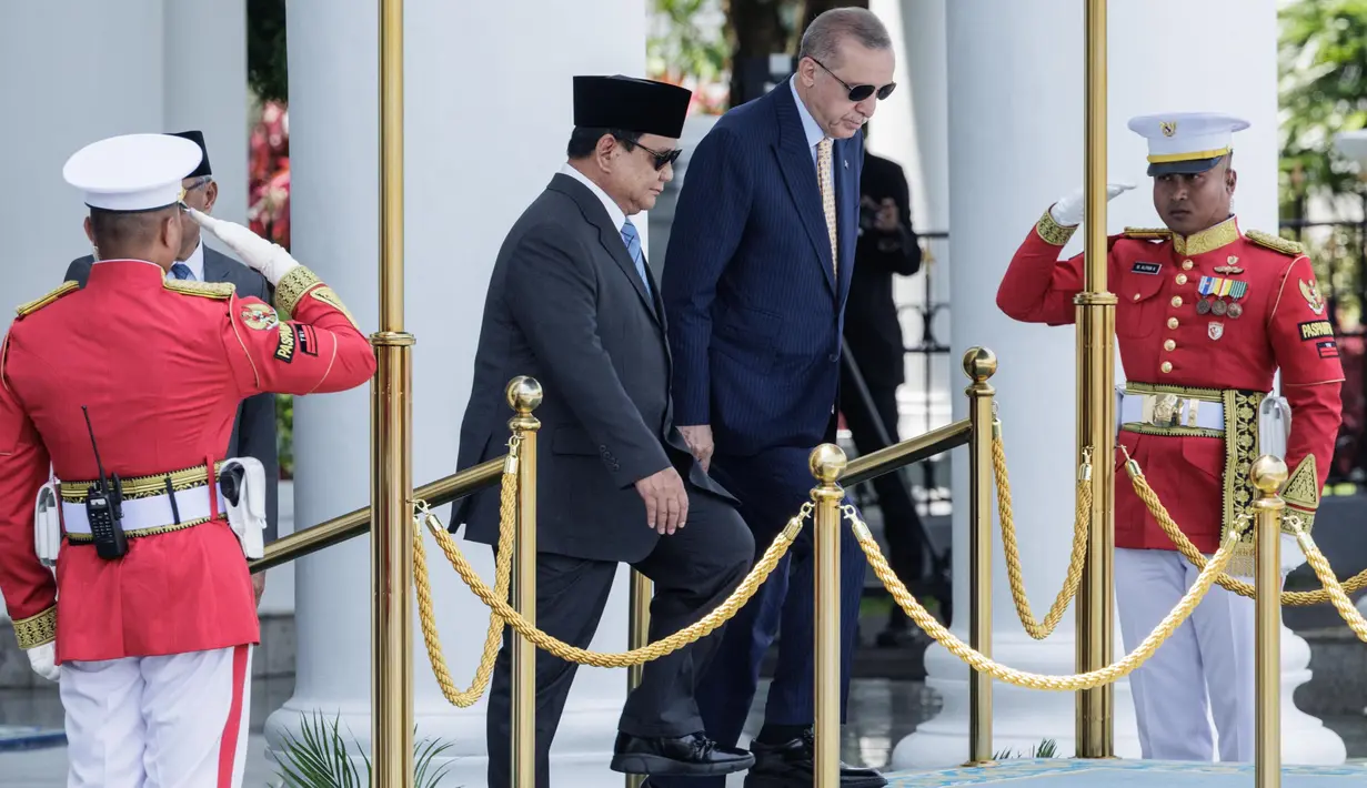 Presiden Indonesia Prabowo Subianto (kiri) dan Presiden Turki Recep Tayyip Erdogan naik ke atas panggung untuk upacara penyambutan di Istana Kepresidenan, Bogor, Jawa Barat, Rabu 12 Februari 2025. (YASUYOSHI CHIBA/AFP)